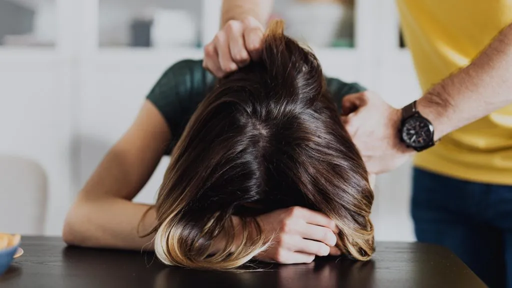 man holding a woman against a table