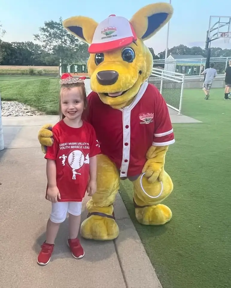 Josh Hodges's daughter with the Joe Nuxhall Miracle League mascot at a Miracle League game